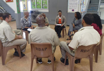 Group of people sitting in a circle for therapy in jail