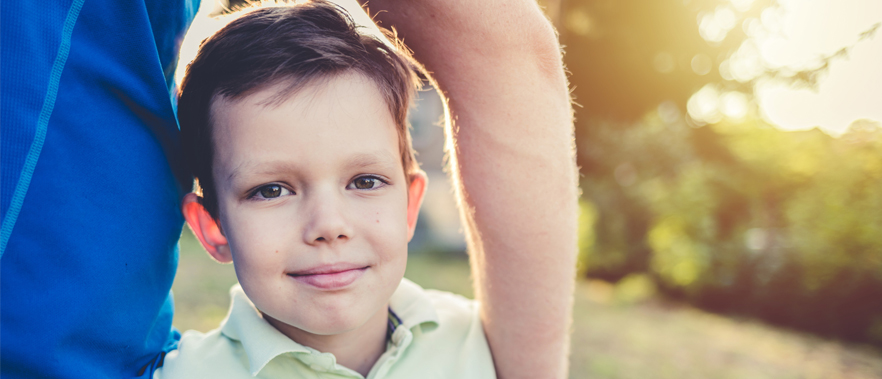 Image of child with male arm around his shoulder