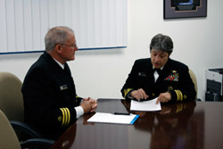 two uniformed people looking at a report