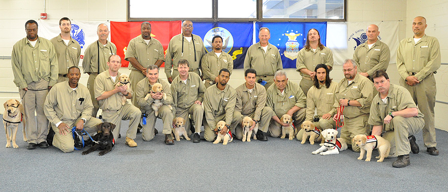 Inmates standing with the training dogs.